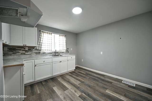 kitchen featuring light countertops, dark wood-type flooring, a sink, and white cabinets