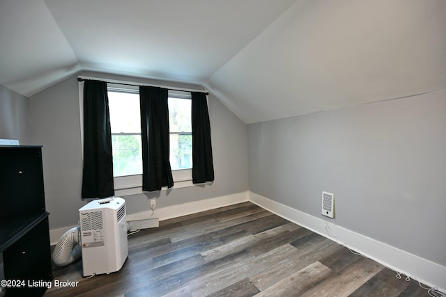 additional living space with lofted ceiling, dark wood-style floors, and baseboards