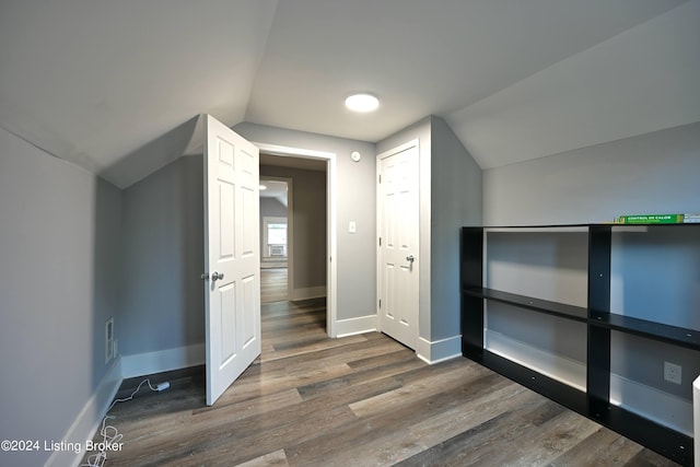 additional living space with lofted ceiling, baseboards, and dark wood-style flooring