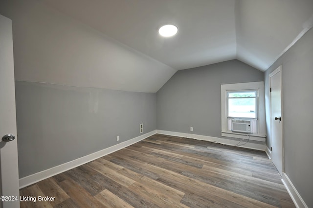 bonus room with dark wood-style floors, cooling unit, vaulted ceiling, and baseboards