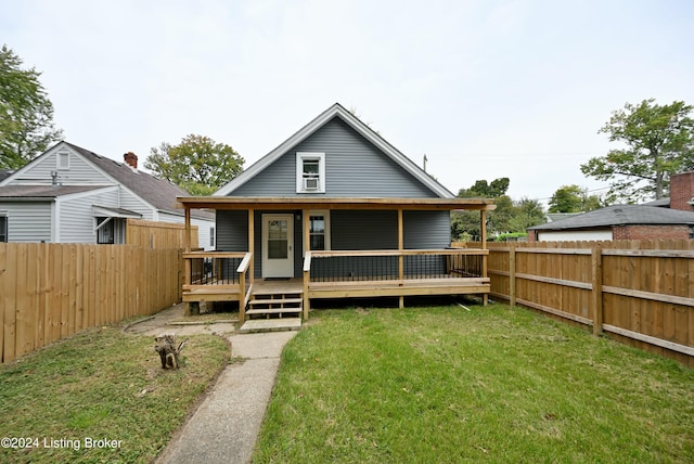 rear view of house featuring a fenced backyard, a lawn, and a wooden deck