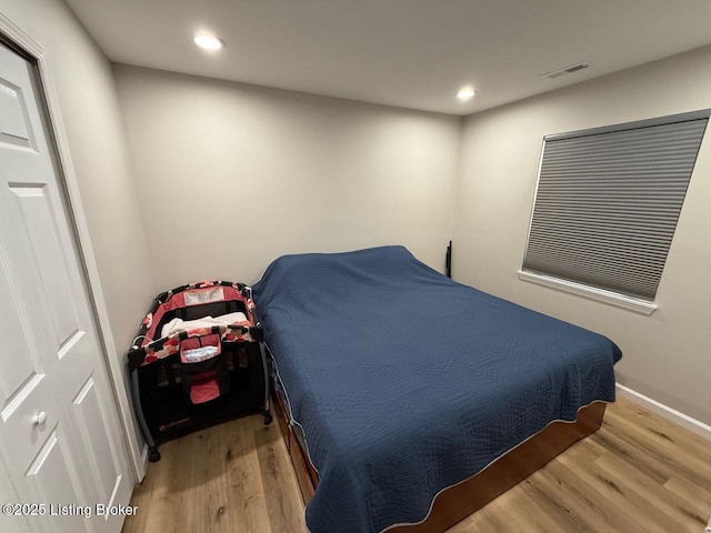 bedroom featuring baseboards, wood finished floors, visible vents, and recessed lighting