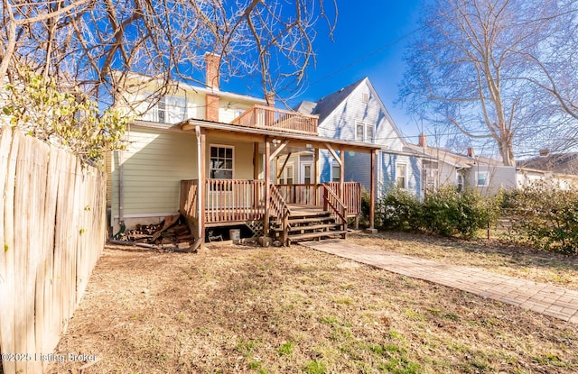 view of front of property with fence, a chimney, and a wooden deck