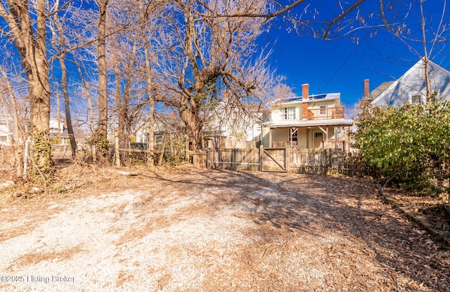 view of front of property with a chimney, a gate, fence, and a porch