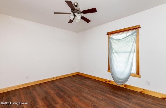 unfurnished room featuring dark wood-style floors, ceiling fan, and baseboards