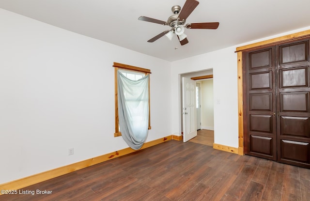 unfurnished bedroom featuring ceiling fan, dark wood-type flooring, and baseboards