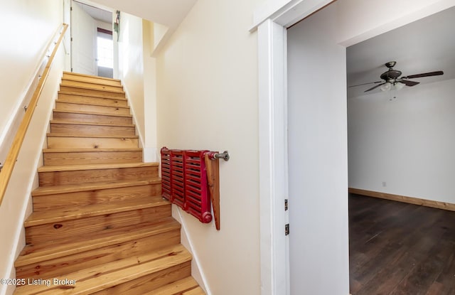 stairway with a ceiling fan, baseboards, and wood finished floors