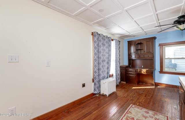 interior space featuring dark wood-type flooring, radiator, baseboards, and a ceiling fan