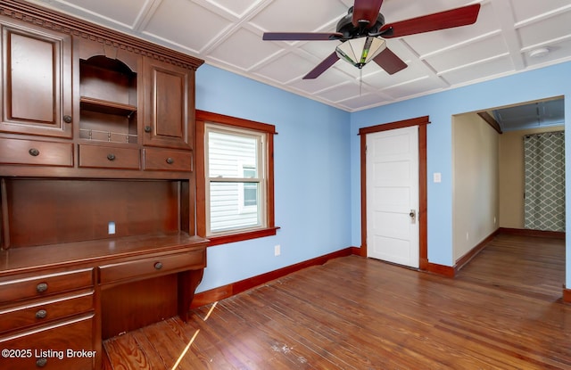 unfurnished office featuring dark wood-type flooring, coffered ceiling, and baseboards