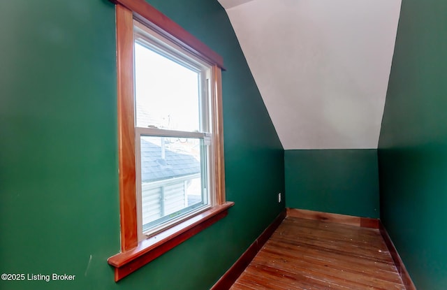 additional living space with lofted ceiling, wood-type flooring, and baseboards