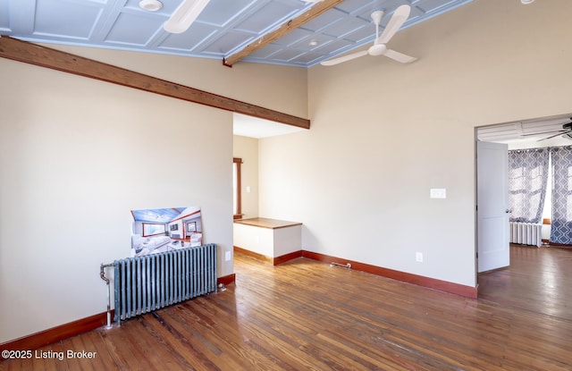 unfurnished room featuring radiator, baseboards, a ceiling fan, and wood finished floors