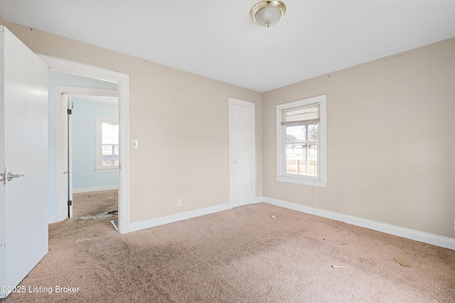 unfurnished room with carpet floors and baseboards