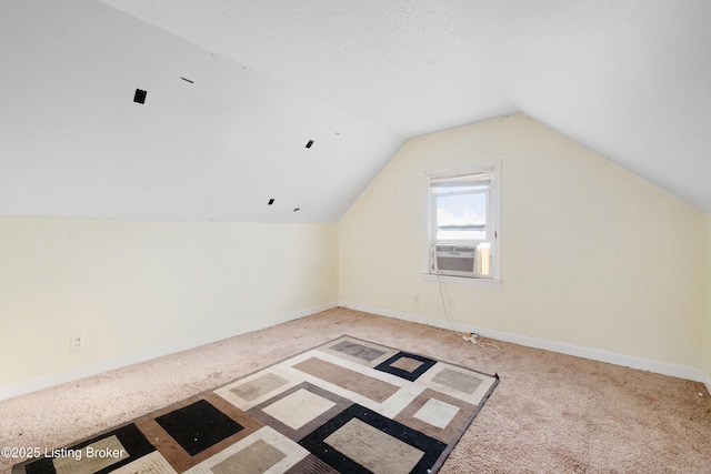 additional living space with cooling unit, carpet flooring, vaulted ceiling, and baseboards