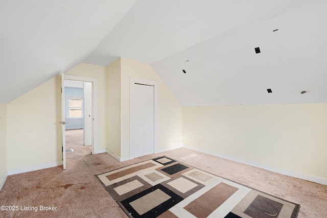 additional living space with lofted ceiling, carpet floors, and baseboards