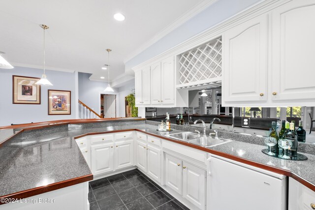 kitchen featuring white dishwasher, ornamental molding, white cabinets, and a sink