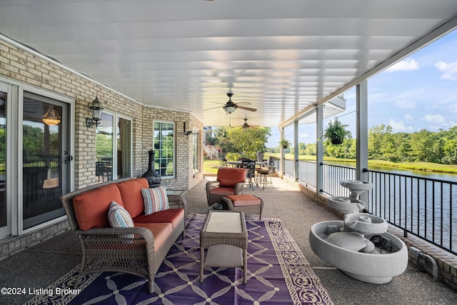 view of patio / terrace with an outdoor living space, a water view, and a ceiling fan