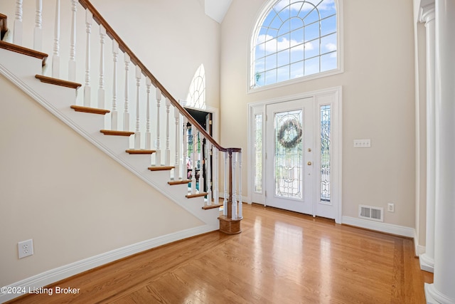 entrance foyer with wood finished floors, visible vents, and baseboards