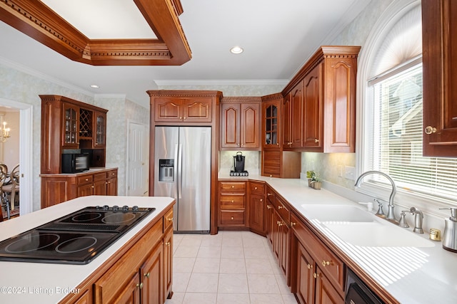 kitchen featuring glass insert cabinets, ornamental molding, light countertops, black appliances, and a sink