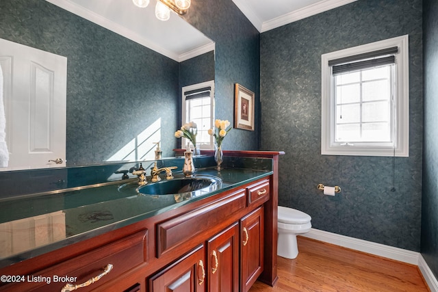 half bath featuring crown molding, toilet, wood finished floors, baseboards, and wallpapered walls