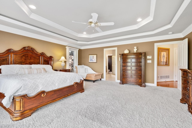 carpeted bedroom with a ceiling fan, a raised ceiling, visible vents, and crown molding