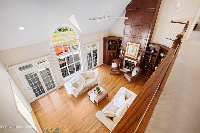 living room featuring a glass covered fireplace, ceiling fan, wood finished floors, high vaulted ceiling, and recessed lighting