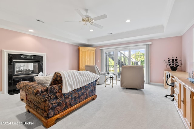 living room with a tray ceiling, light colored carpet, visible vents, and crown molding