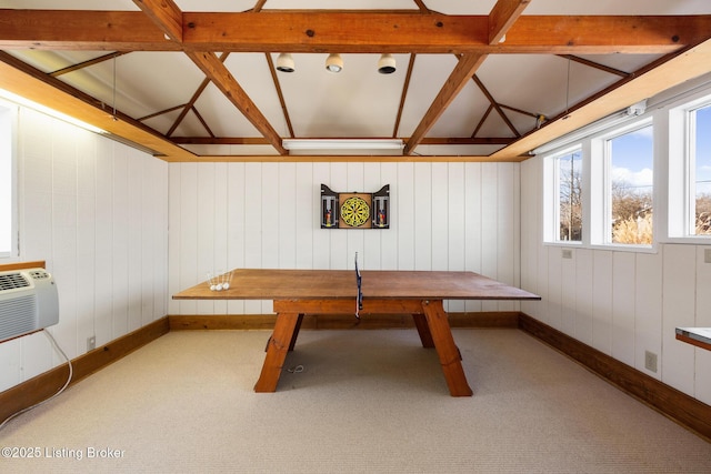 interior space featuring vaulted ceiling, carpet floors, a wall mounted AC, and baseboards