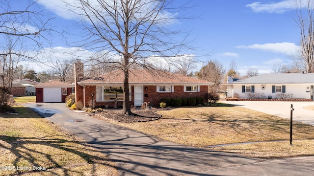 ranch-style house featuring brick siding, driveway, and a chimney