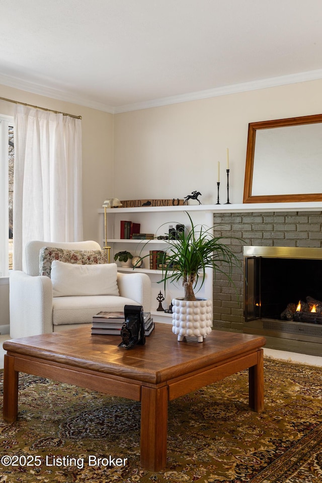 living area featuring a brick fireplace and crown molding