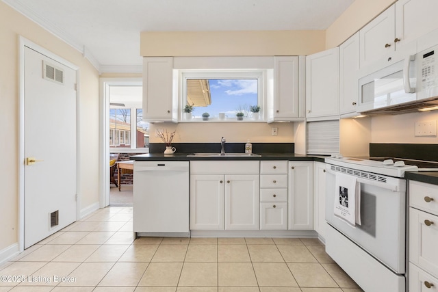 kitchen with white appliances, visible vents, a sink, and light tile patterned flooring