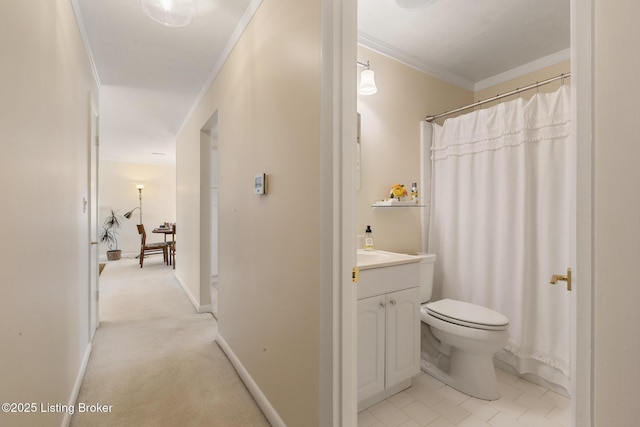 bathroom with toilet, baseboards, vanity, and crown molding