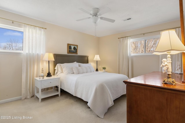 bedroom featuring light carpet, ceiling fan, visible vents, and baseboards