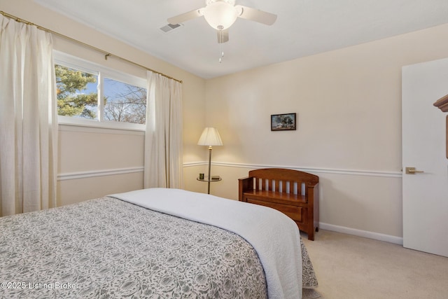 bedroom with baseboards, a ceiling fan, visible vents, and light colored carpet