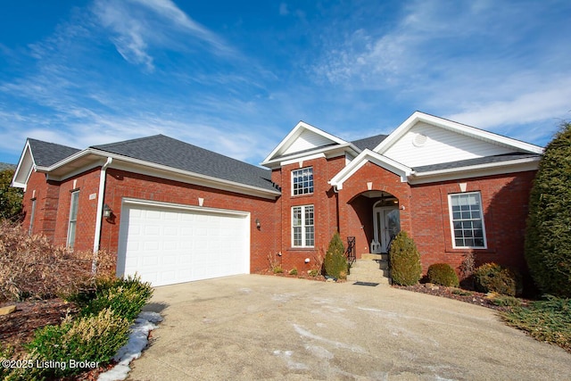 view of front of house with a garage, a shingled roof, concrete driveway, and brick siding