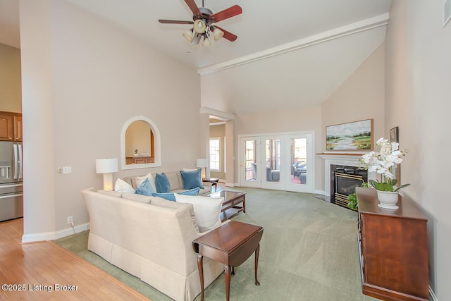 living area with high vaulted ceiling, a fireplace, and baseboards