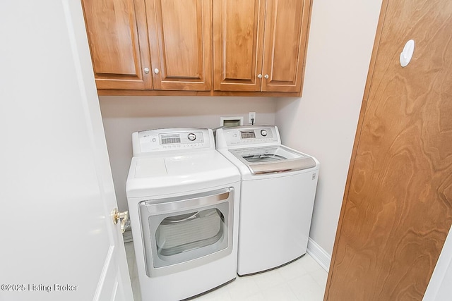 laundry area featuring cabinet space, baseboards, and washer and clothes dryer