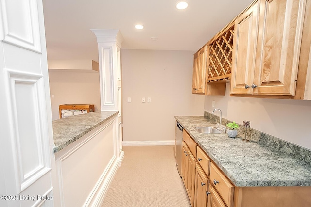 kitchen featuring recessed lighting, a sink, baseboards, stainless steel dishwasher, and ornate columns