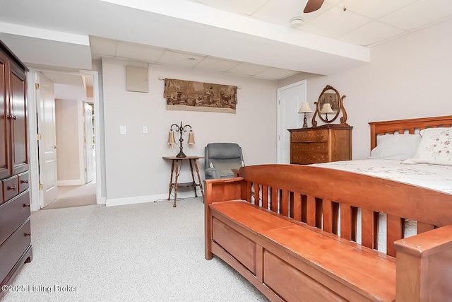 bedroom with a drop ceiling, ceiling fan, and baseboards