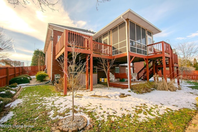 back of property featuring a sunroom, a fenced backyard, stairway, and a wooden deck