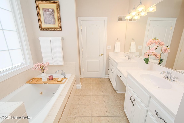 full bath with double vanity, visible vents, a tub with jets, tile patterned floors, and a sink