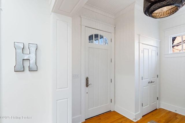 foyer entrance with light wood-style flooring and baseboards