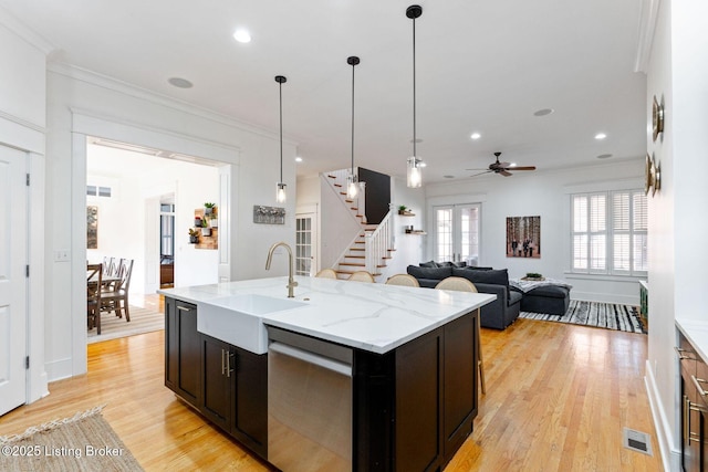 kitchen with crown molding, visible vents, a sink, and stainless steel dishwasher