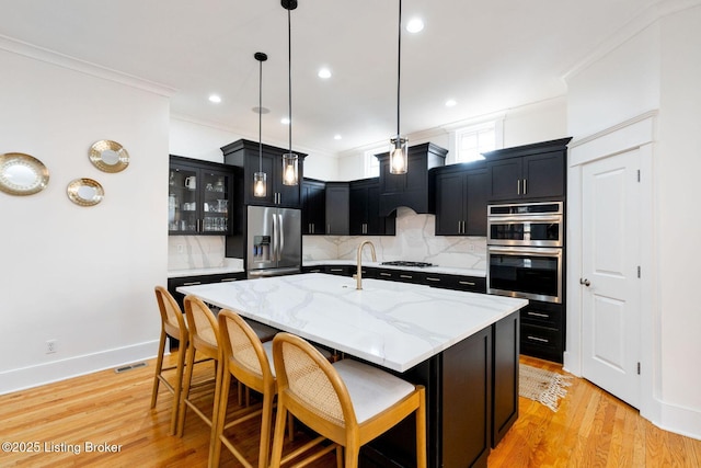 kitchen featuring appliances with stainless steel finishes, a breakfast bar, dark cabinets, and ornamental molding