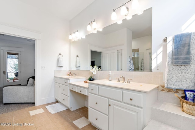 ensuite bathroom featuring tasteful backsplash, a stall shower, connected bathroom, vanity, and tile patterned floors