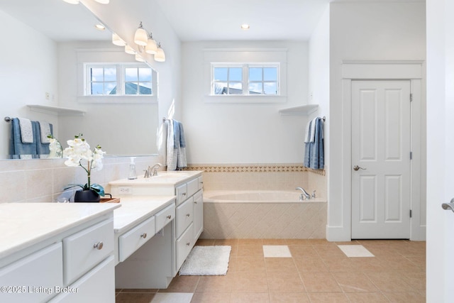 full bath with a garden tub, tile patterned flooring, vanity, and a healthy amount of sunlight