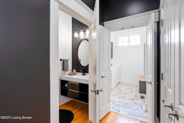 bathroom featuring baseboards, wood finished floors, and vanity