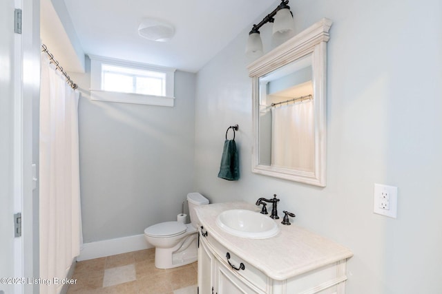 bathroom featuring baseboards, vanity, and toilet