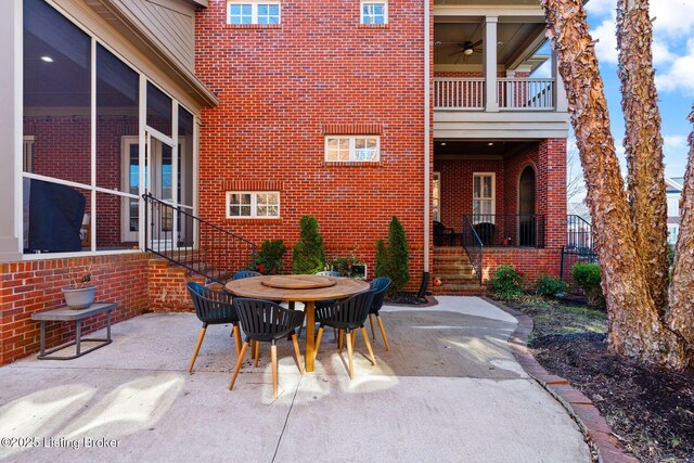 view of patio featuring ceiling fan, outdoor dining space, and a balcony