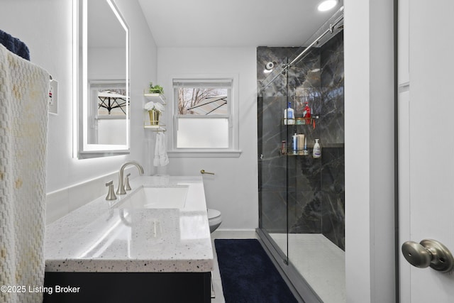 bathroom featuring a marble finish shower, baseboards, vanity, and toilet