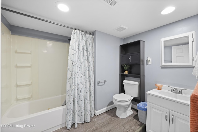 bathroom with toilet, wood finished floors, vanity, visible vents, and shower / tub combo with curtain